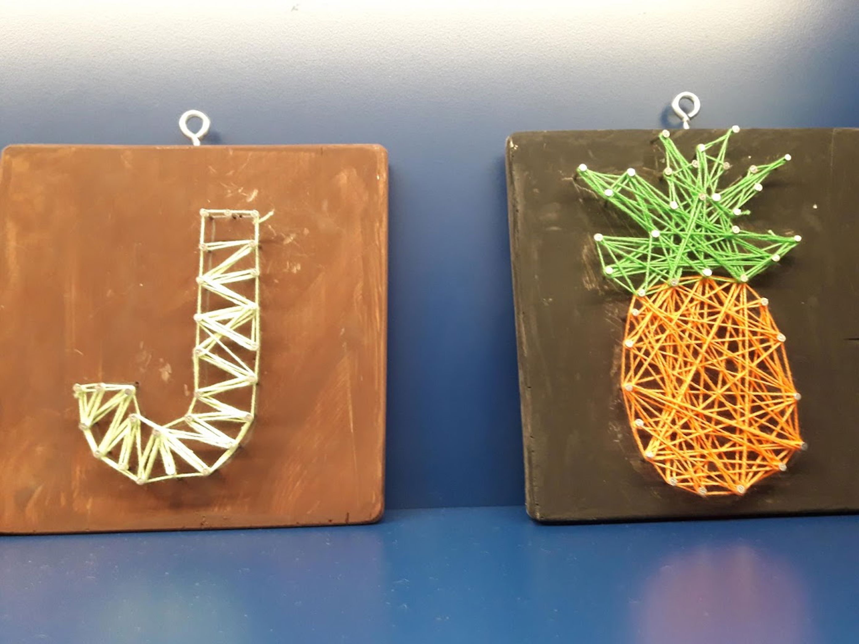 Spikerbilde bokstav J med lys tråd og ananas i oransje og grønt