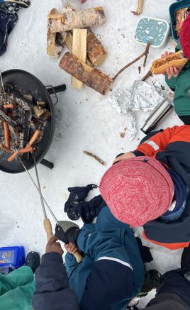 En gruppe mennesker i et snødekt område med et bål En gruppe mennesker i et snødekt område med et bål