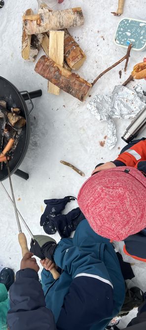 En gruppe mennesker i et snødekt område med et bål En gruppe mennesker i et snødekt område med et bål