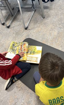 et par barn som sitter ved et bord og ser på en bok