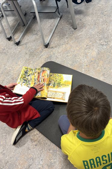 et par barn som sitter ved et bord og ser på en bok