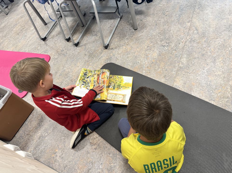 et par barn som sitter ved et bord og ser på en bok